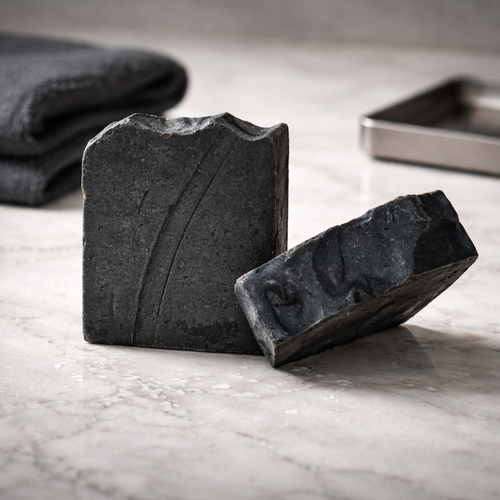 Handmade black citrus scrub cold process soap bar with activated charcoal, pumice and orange essential oil by Natural Misfit Soap Studio